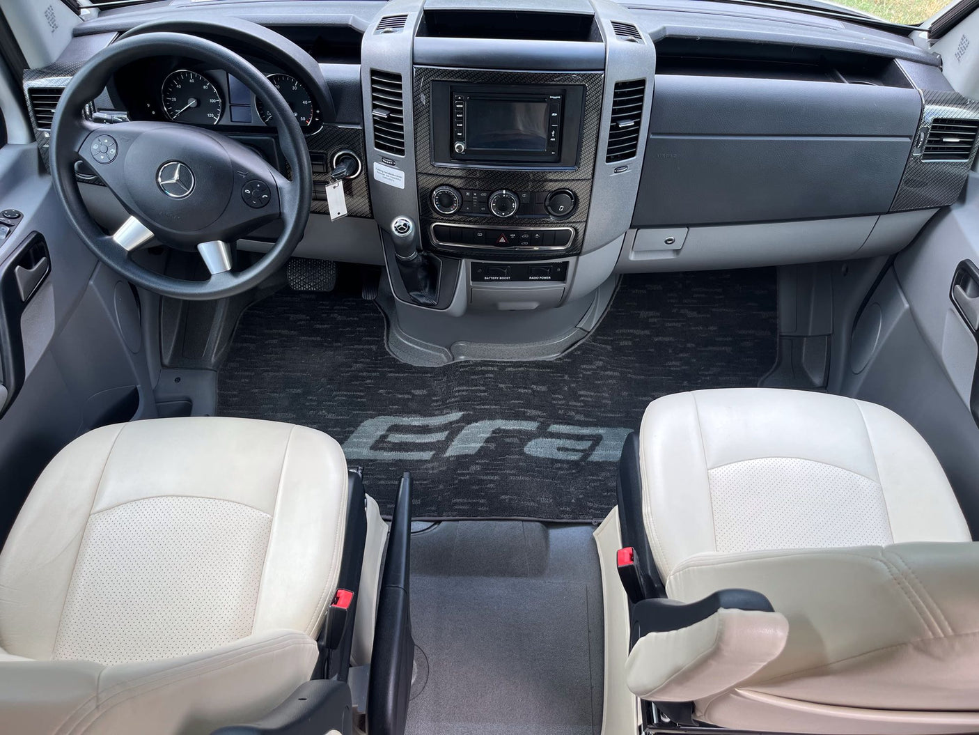 and cream sofa. Perfect for travel adventures.|RV rental: Open microwave oven with grill rack inside a compact kitchen area.|Open Norcold RV refrigerator in an rv rental