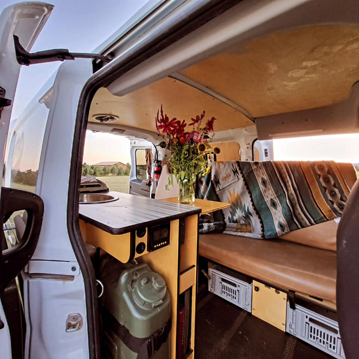 revealing its cozy interior. Perfect for your next RV rental adventure.|Inside a custom RV rental camper van: compact kitchen