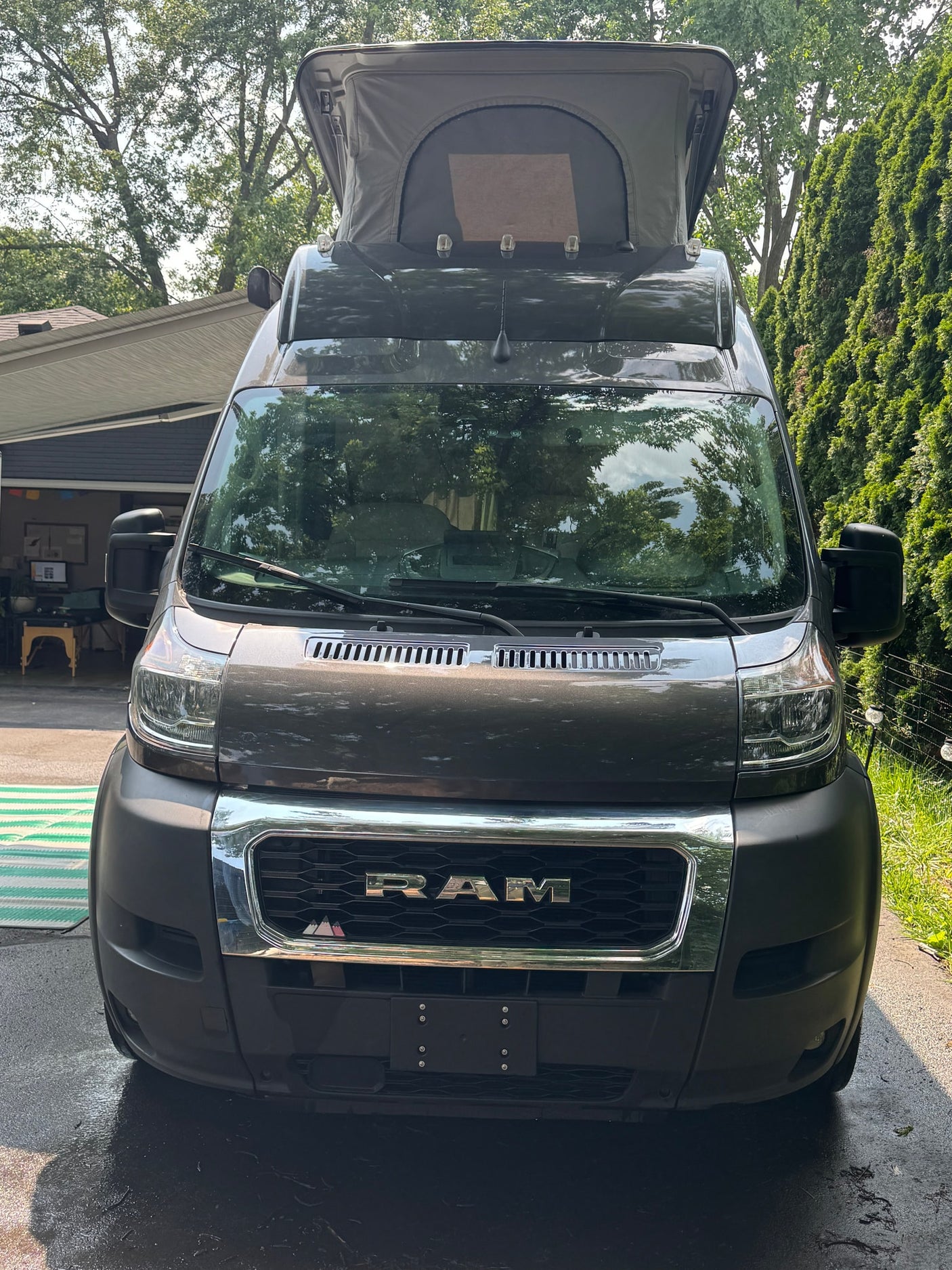 Front view of a dark gray Ram ProMaster pop-top camper van, ideal for your next RV rental adventure.