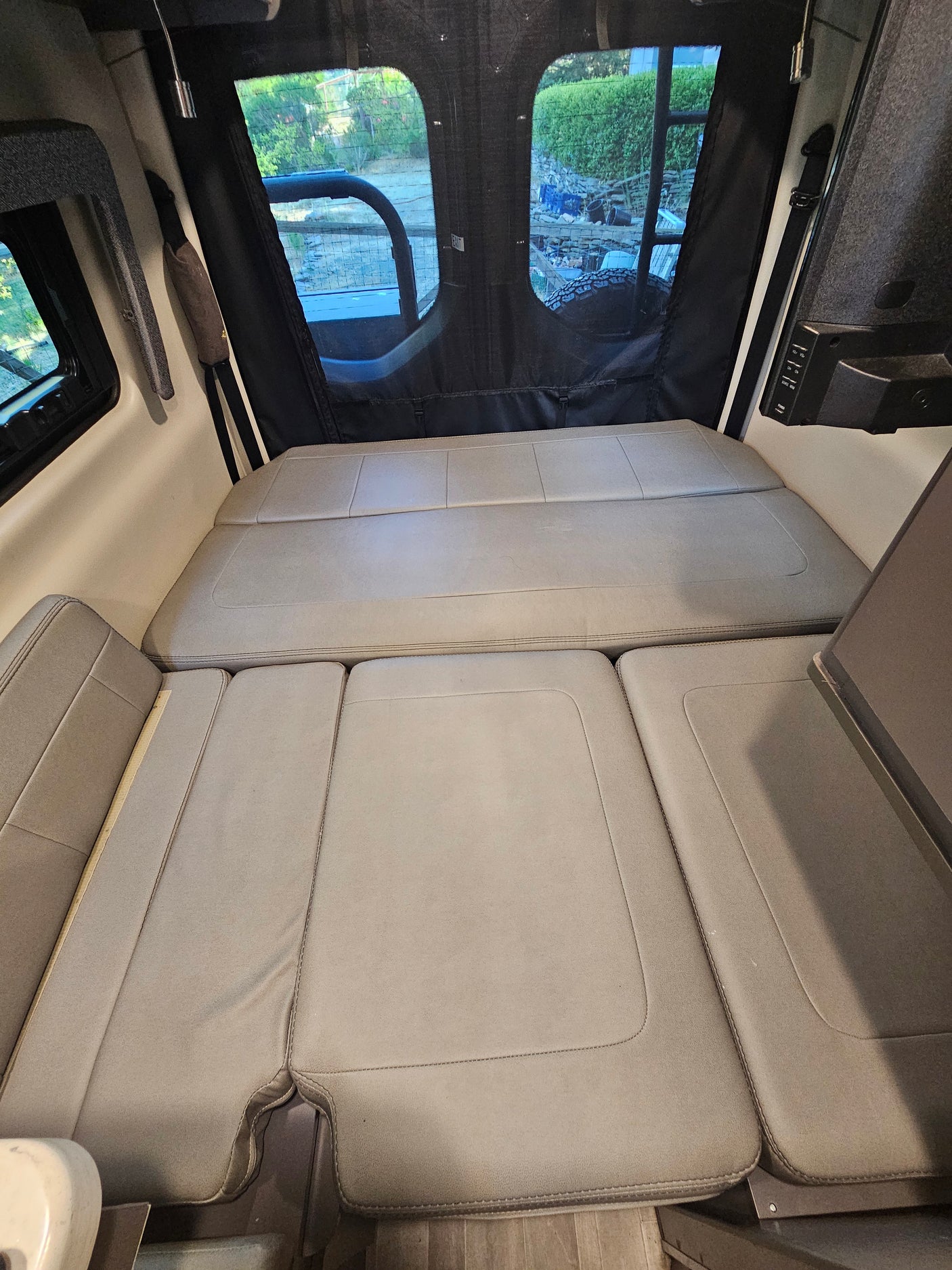 Comfortable RV rental interior featuring convertible seating for a full bed, ideal for road trips.