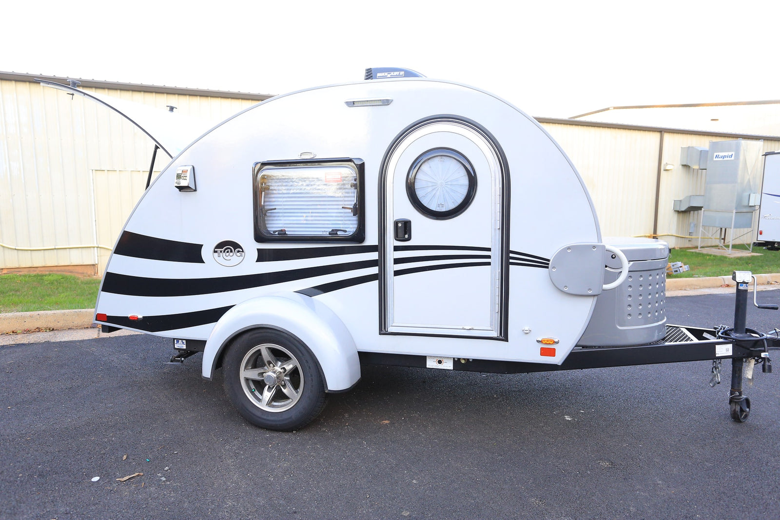 This compact white teardrop RV, featuring stylish black stripes, is perfect for your next rv rental adventure. Ready to hit the road!