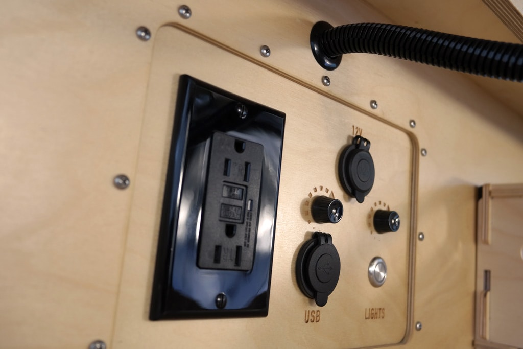 light switch. Mirror reflects ceiling fan overhead.|RV rental interior: overhead light wood cabinets