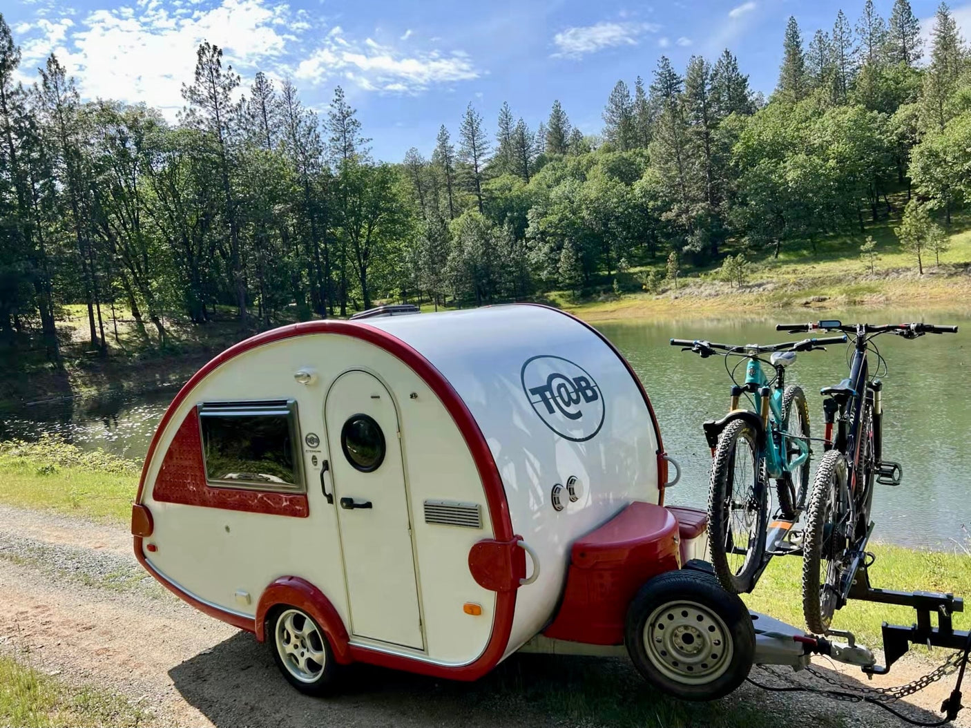 Teardrop camper by a lake with bikes