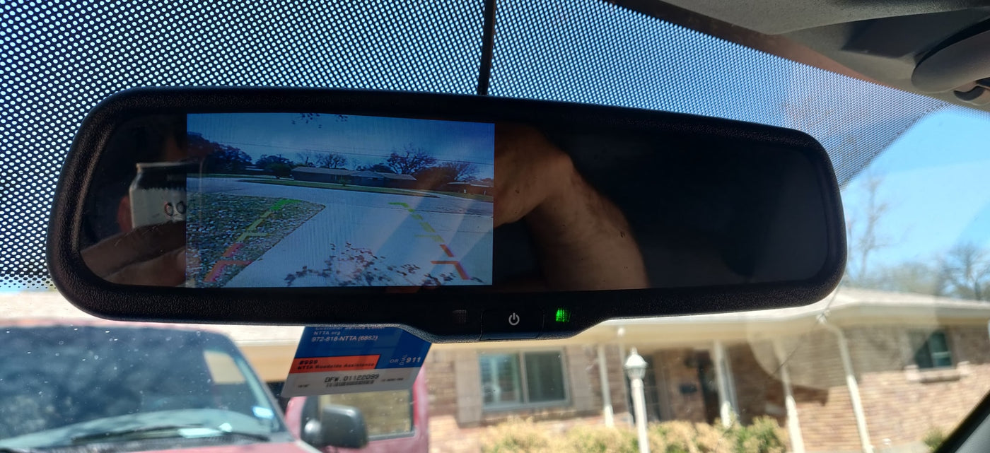 A car's rearview mirror with backup camera display and NTTA sticker. This safety feature is essential for parking, especially with an RV rental. — photo 15