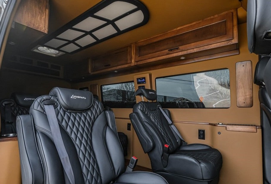 Luxury RV rental interior with plush black leather seats, wood cabinets, and ambient lighting, perfect for a comfortable journey. — photo 10
