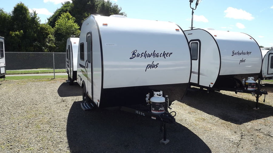 Multiple white Bushwhacker Plus travel trailers for RV rental