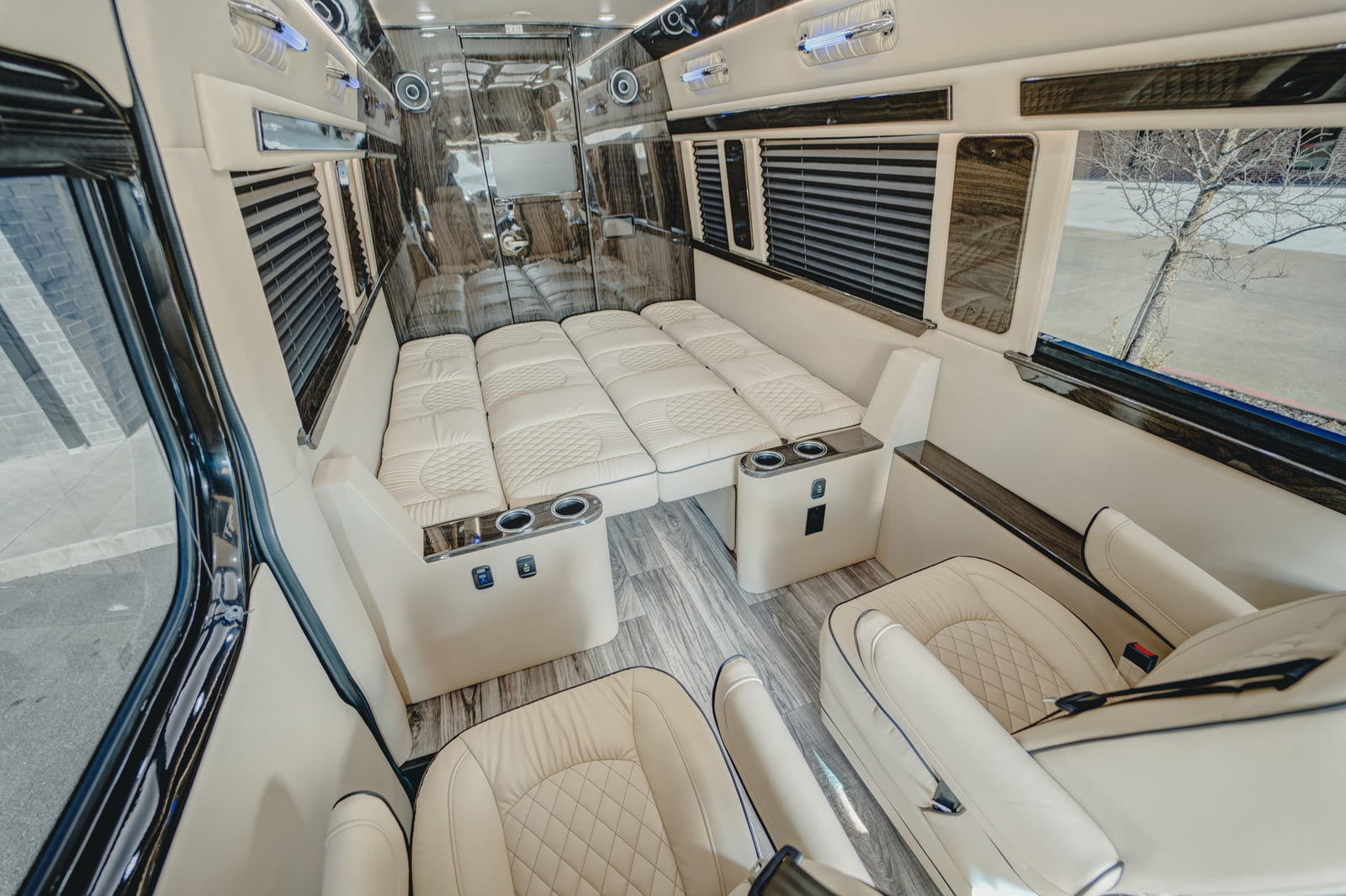 and overhead entertainment.|Luxury RV rental interior: view of a spacious bedroom with two plush cream-colored beds