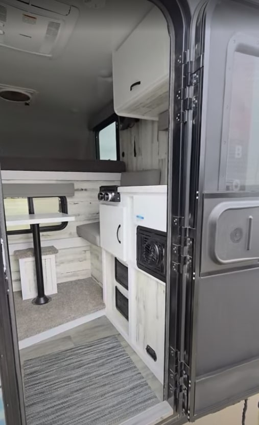 parked outside Fedde RV service.|Compact truck camper on a specialized trailer