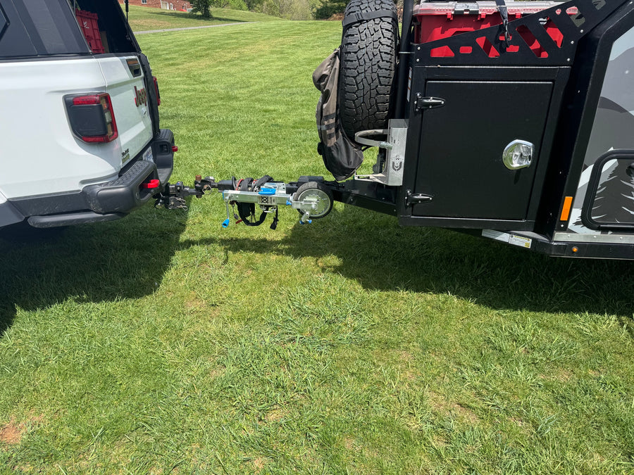 White Jeep truck hitched to an off-road trailer with a bike rack. Ideal setup for an RV rental adventure.