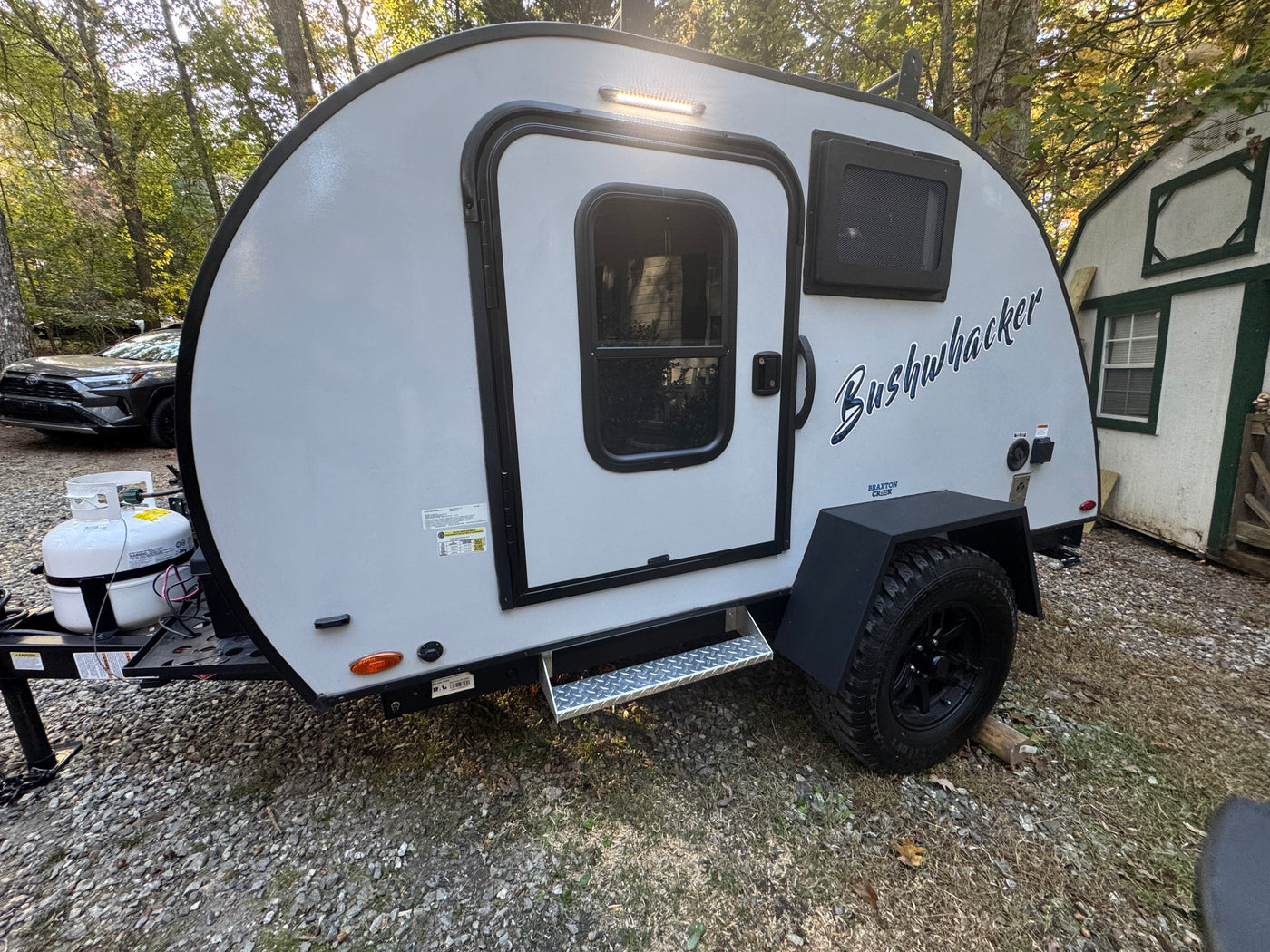 This light grey Bushwhacker teardrop camper makes a great RV rental, parked on gravel for outdoor adventures. — photo 10