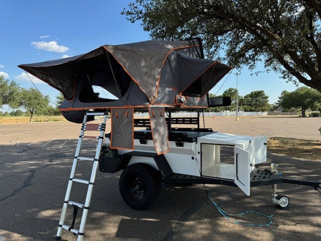 perfect for an RV rental adventure.|Explorer Bear cooler on an RV rental pull-out tray for easy access during camping trips.|Overlanding RVs & rooftop tents camped in a red rock desert. Your next adventure awaits with an RV rental!|White Jeep Gladiator towing an overland camper trailer in red rock country. An ideal **RV rental** for off-road adventures!|Starry desert night: Jeeps
