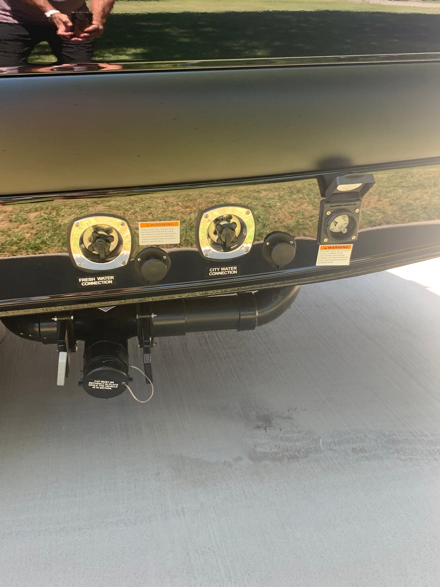 RV rental utility panel showing fresh/city water connections, 30-amp electrical hookup, and waste dump valves below.