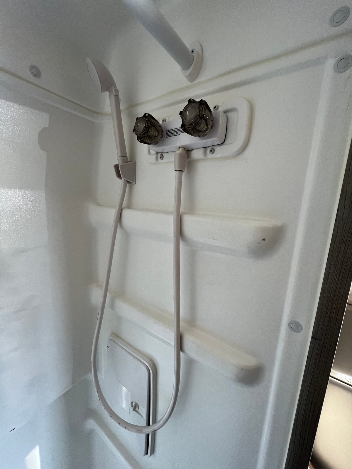 natural light from side windows.|Cozy bed inside an RV rental: a plush blue blanket with warm-toned stripes — photo 16