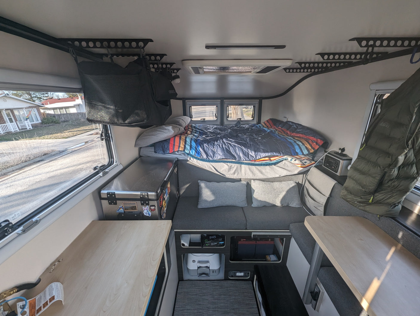 Step inside this RV rental: a compact interior featuring a comfortable bed, seating, and organized storage.