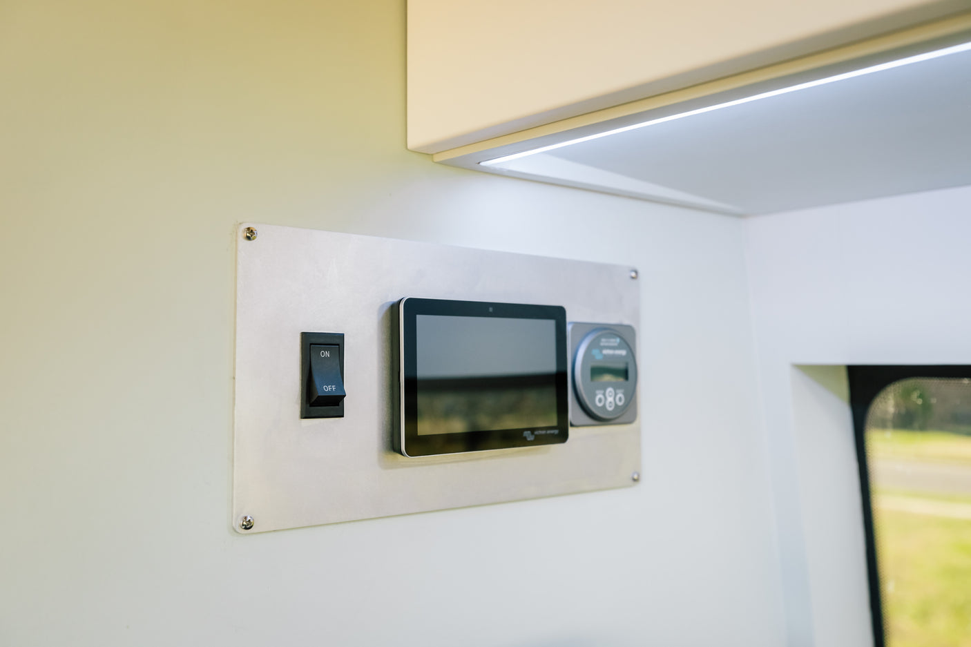 RV rental interior: A control panel features an ON/OFF switch, display tablet, and power monitor for managing onboard systems.