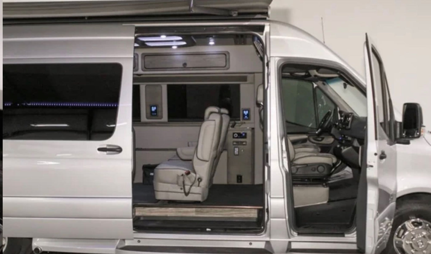 Get a glimpse inside this silver luxury RV rental van! Open doors reveal spacious, custom interior with comfortable seating. — photo 3