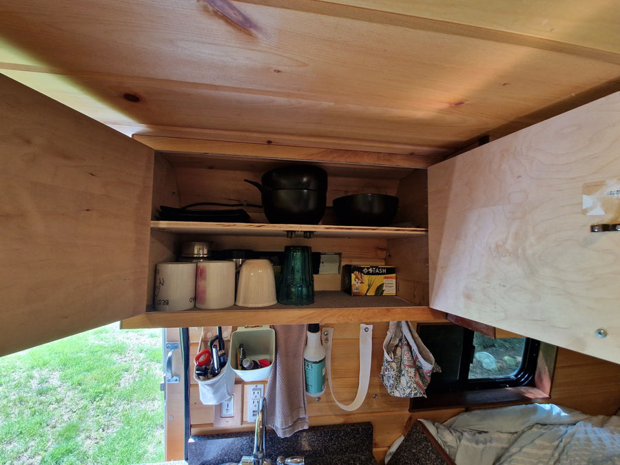 and handy storage for your next adventure.|Step inside this cozy RV rental's wooden interior