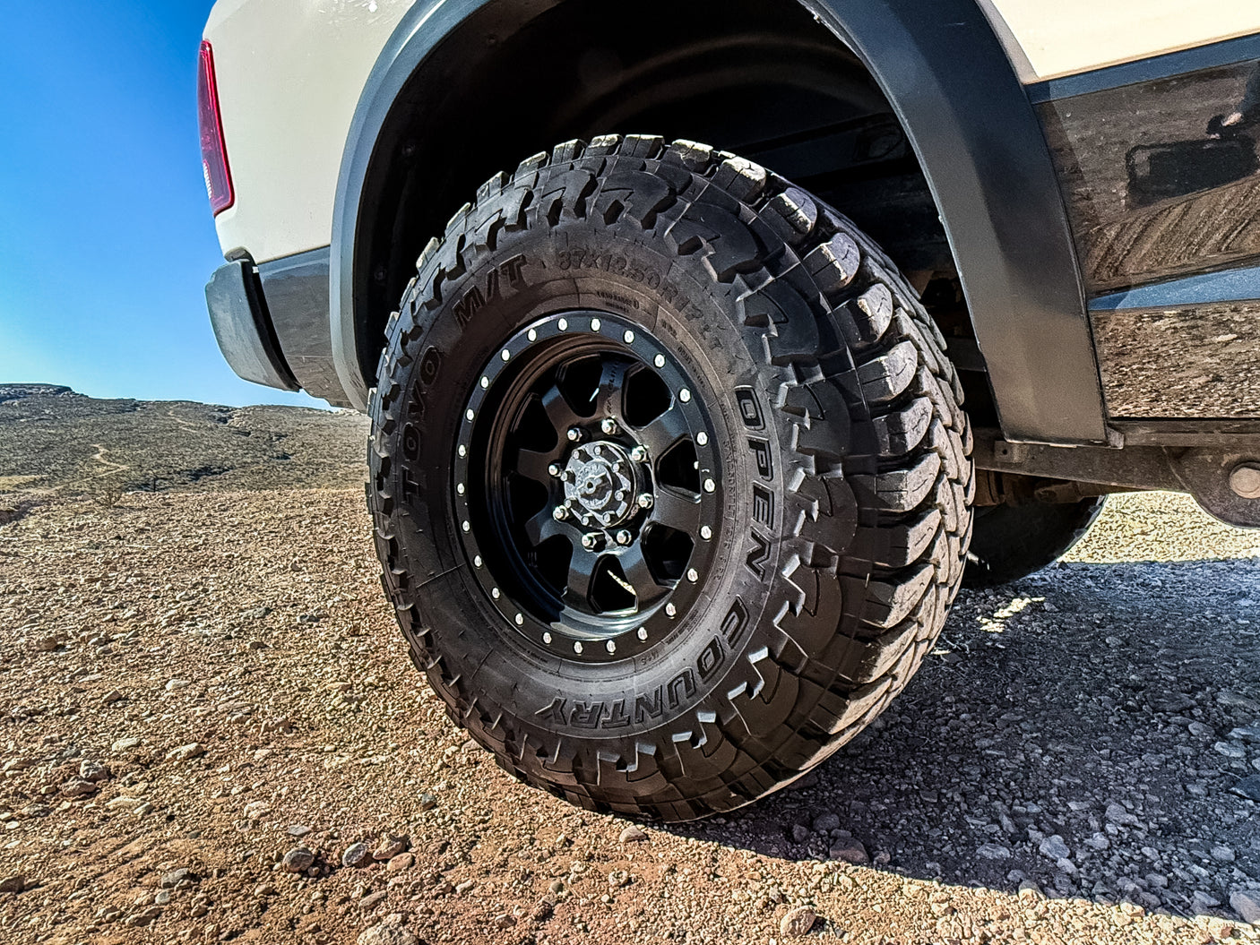Close-up of a rugged off-road tire on an RV rental truck, ready for desert adventures on rocky terrain.