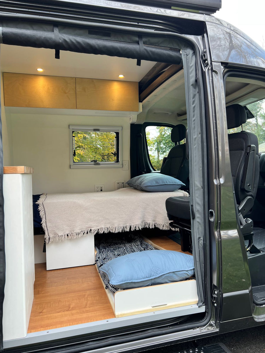 and a portable toilet. Perfect for road trip comfort.|RV rental: Compact interior with a raised bed