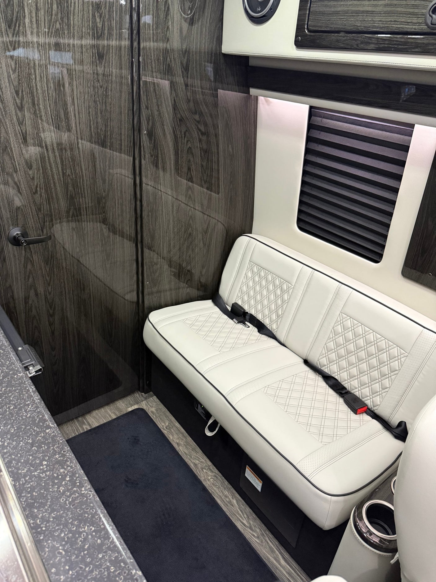 and elegant finishes for luxury travel.|Luxury RV rental: two white quilted captain's chairs with wood tables