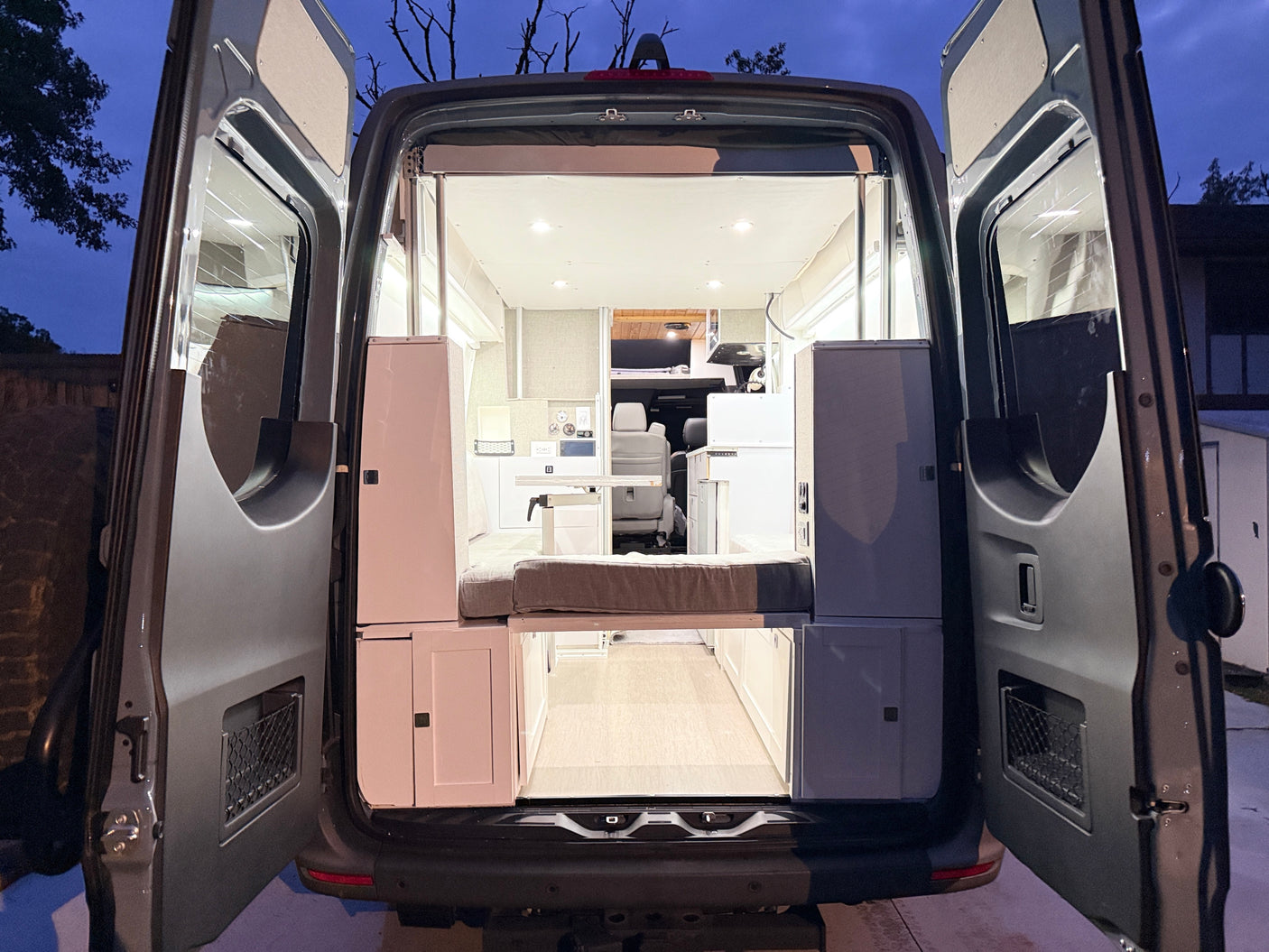 perfect for on-the-go convenience.|Modern RV rental interior: sleek camper van conversion with seating
