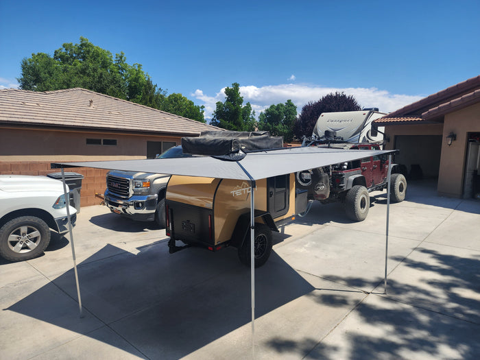 This RV rental setup, featuring a Teton camper, truck, and Jeep on a sunny driveway, is ready for your outdoor adventure!