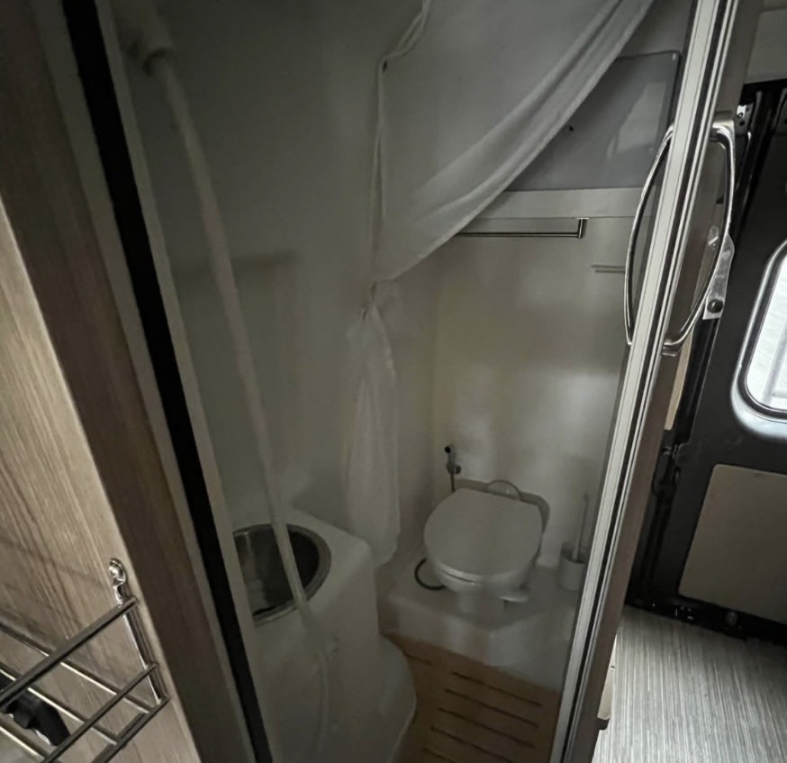 and driver's cabin. Ideal camper living space.|This RV rental's interior features a compact kitchen with sink/stove