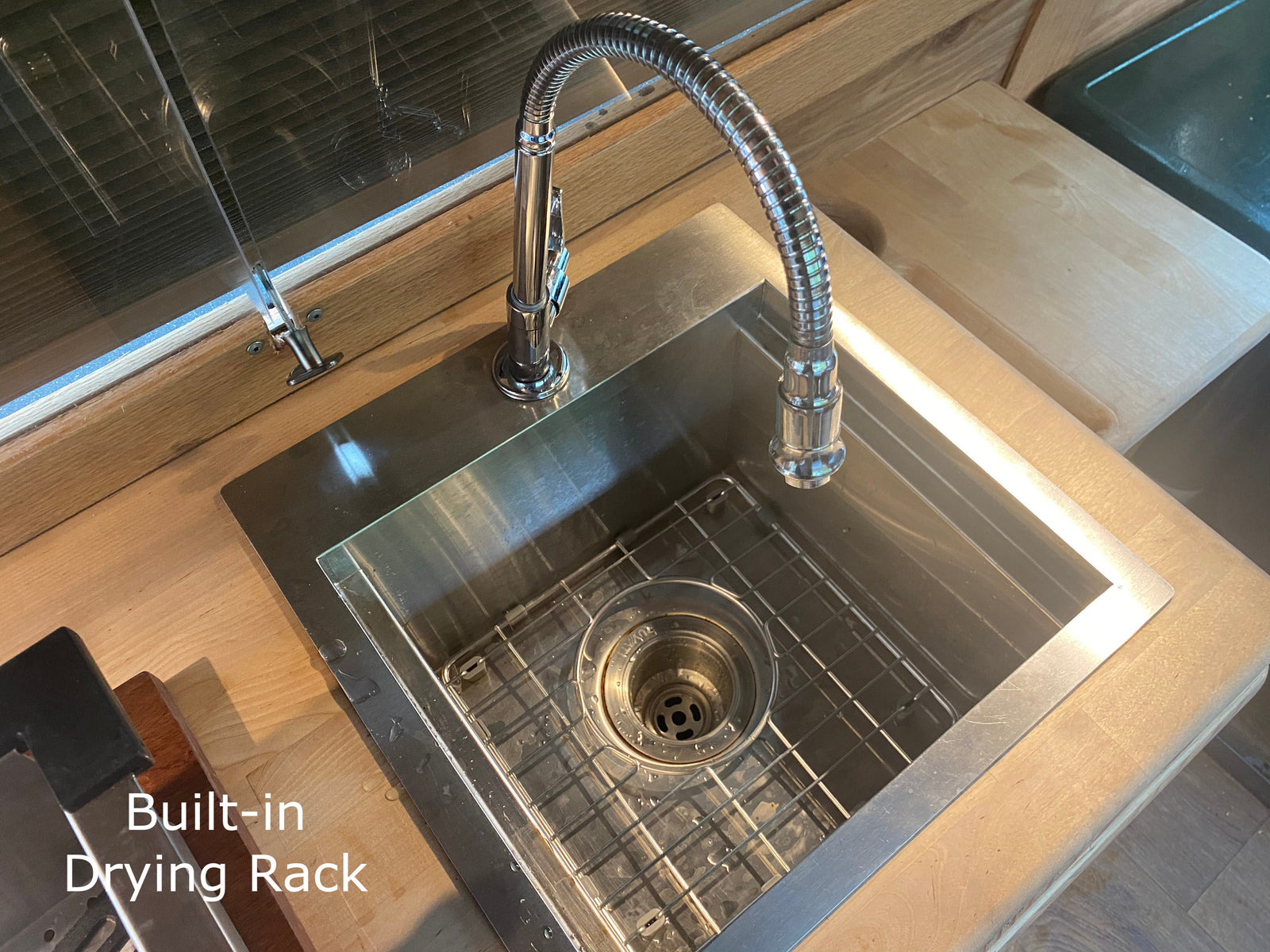 RV rental kitchen featuring a modern stainless steel sink with a flexible faucet and built-in drying rack.