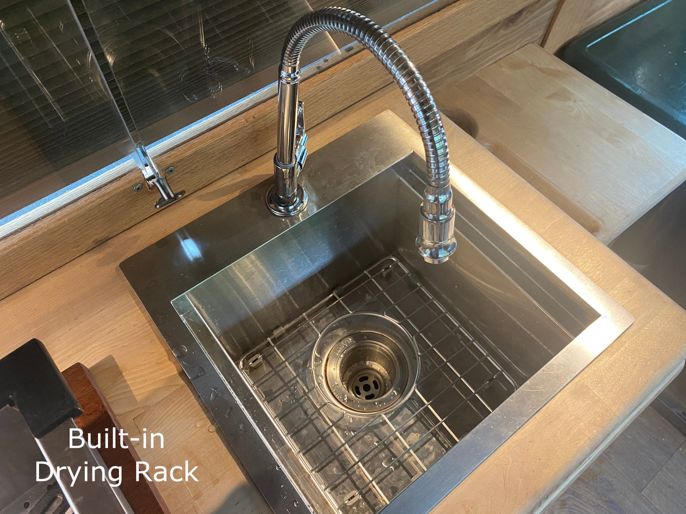 RV rental kitchen featuring a modern stainless steel sink with a flexible faucet and built-in drying rack.