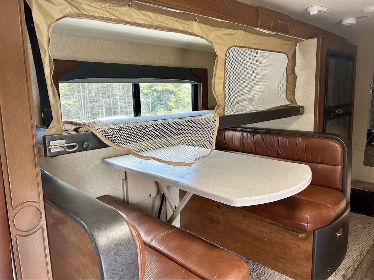 is ready for adventure. Open door & outdoor step visible.|This RV rental features a bright interior with a dining booth