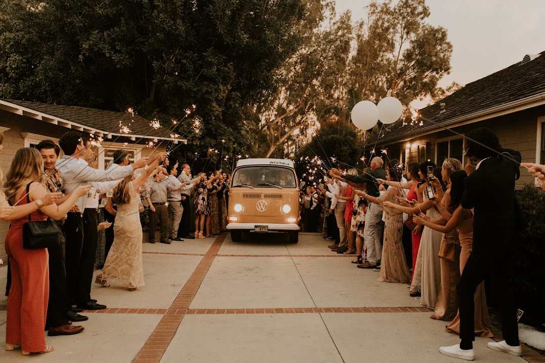 A vintage VW bus RV rental drives through a dazzling sparkler send-off, celebrating a joyous event. — photo 16