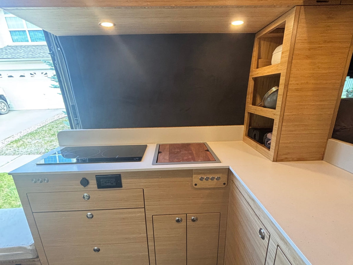 and comfortable bed area.|Cozy bed setup inside an RV rental with a window view of green grass — photo 4