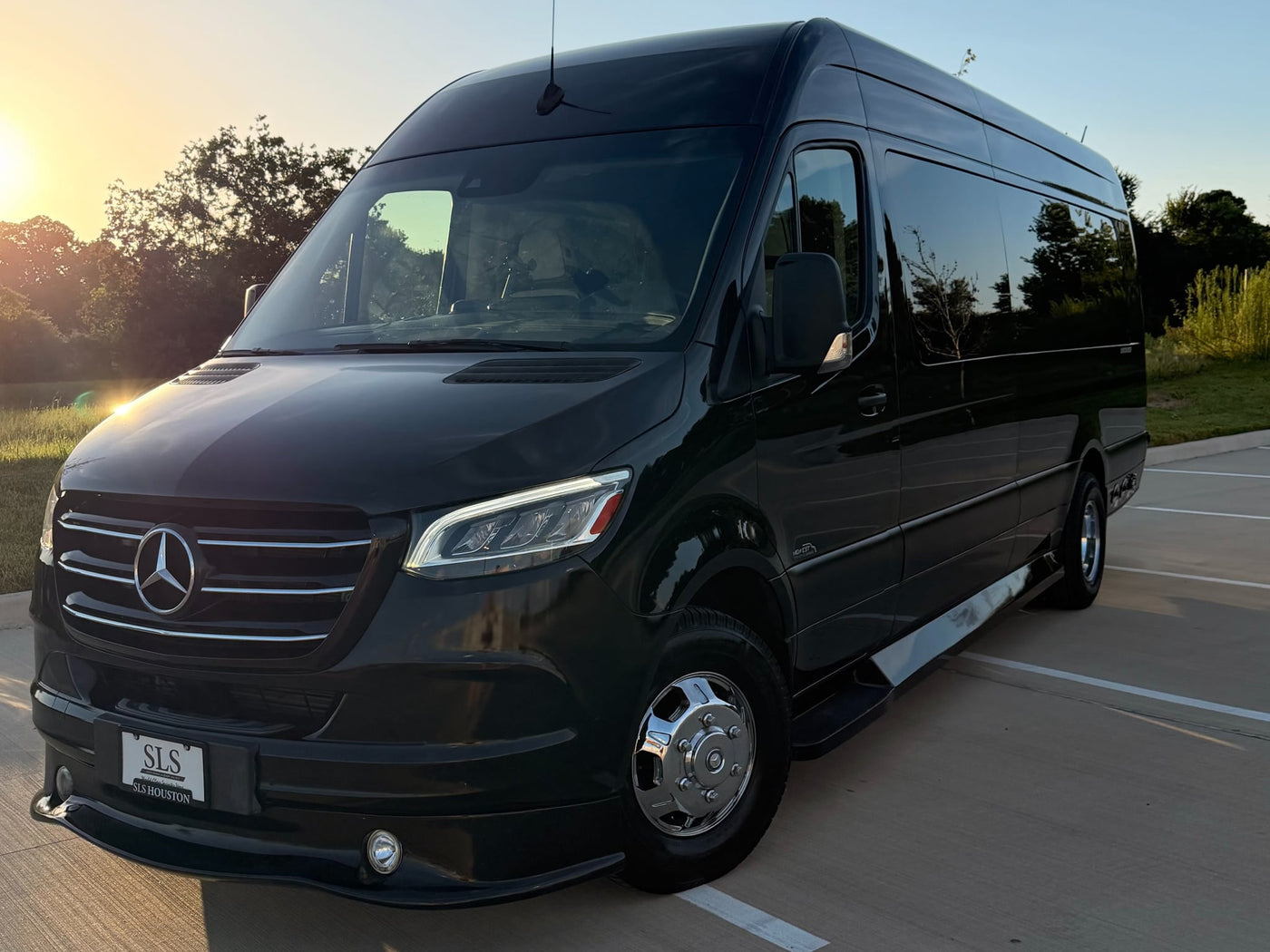 parked on a sunny day.|Luxury black RV rental van: side door open reveals a plush — photo 3