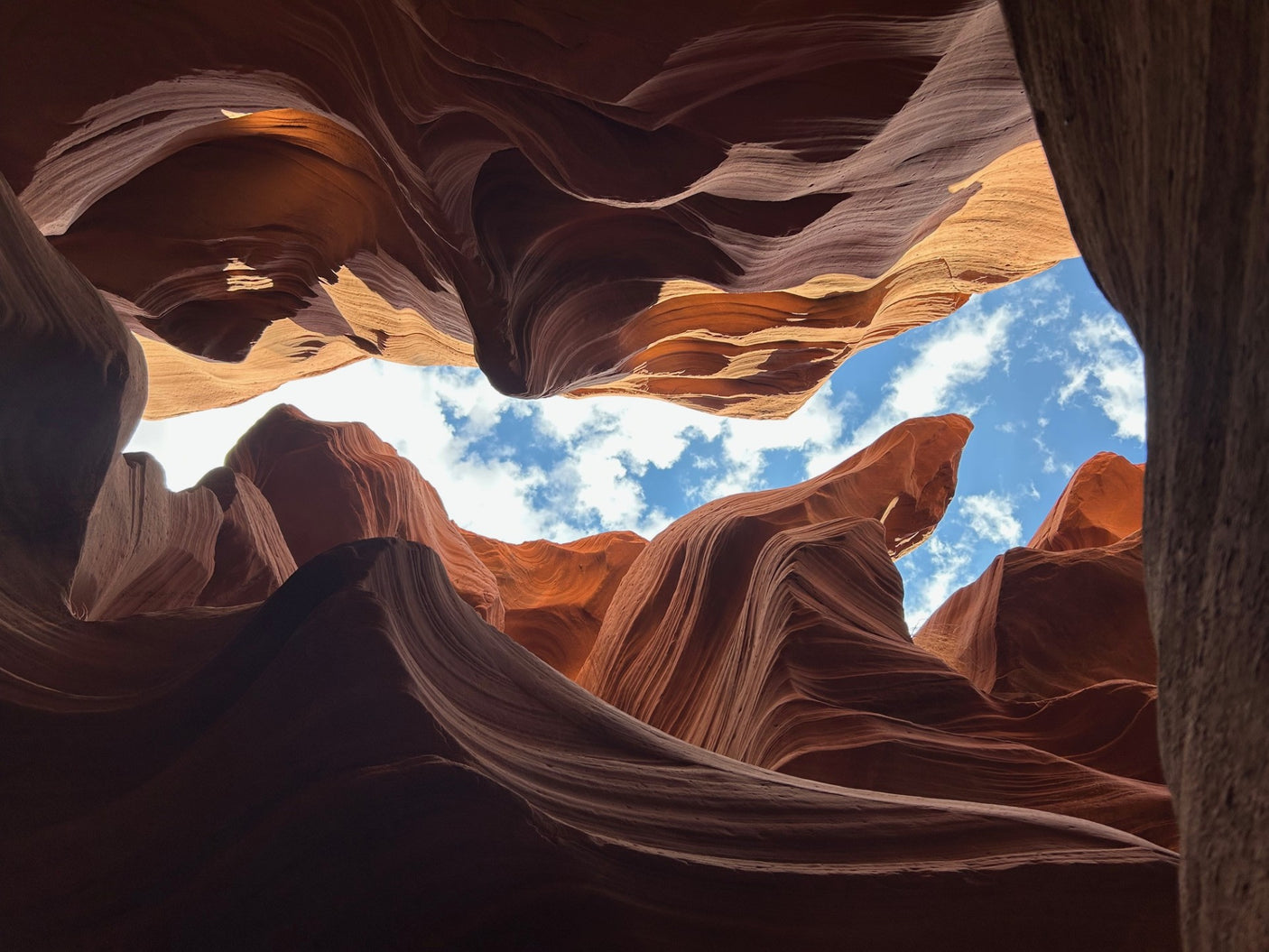 Antelope Canyon's swirling orange sandstone walls frame a vivid blue sky. Discover such natural wonders with an RV rental adventure.