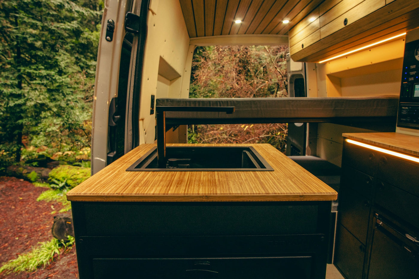 wood-paneled interior.|Experience a functional RV rental. This custom camper van showcases an elevated bed — photo 11