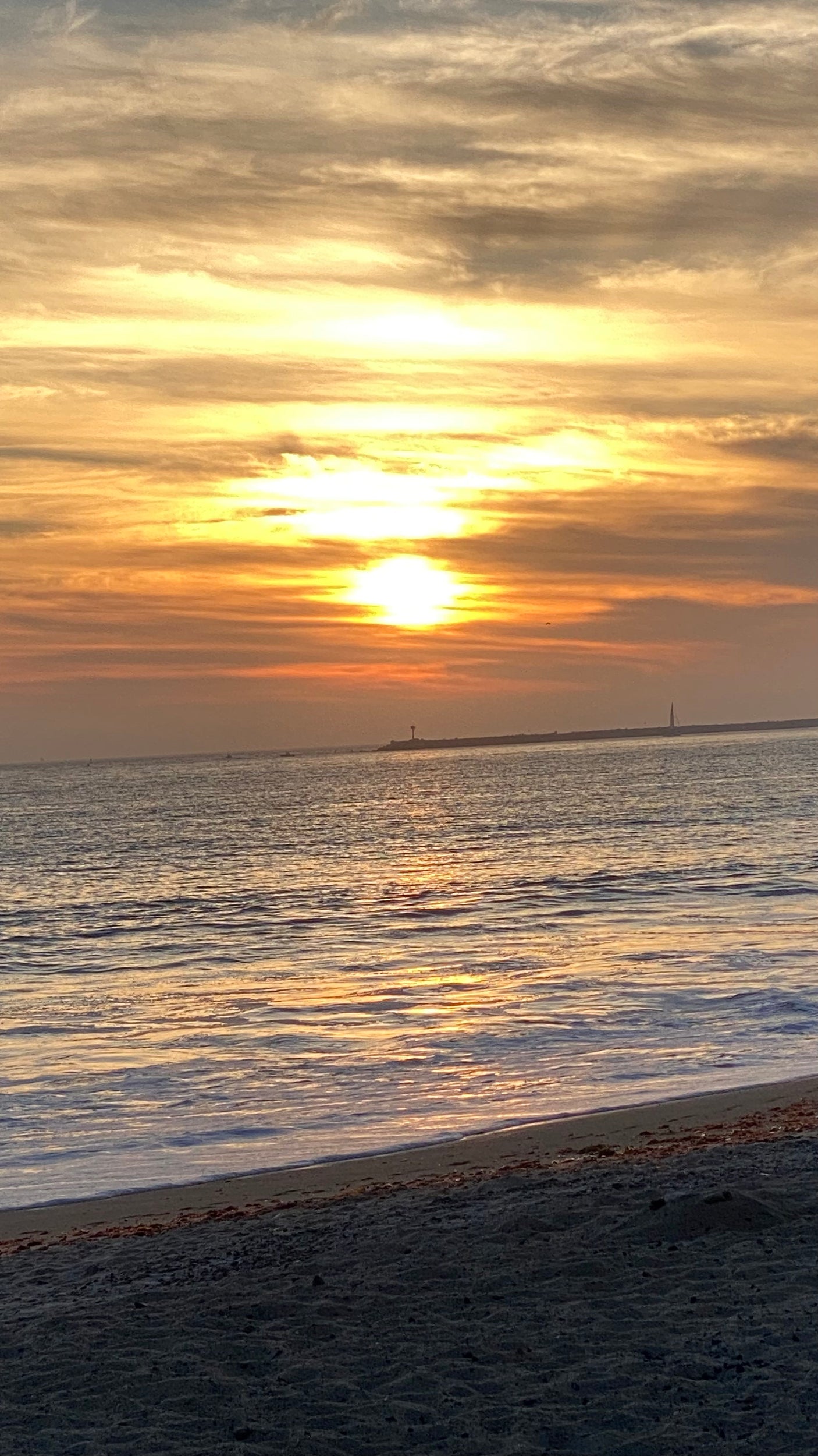 Serene golden sunset over ocean waves & sandy beach. An RV rental escape offers views like this!