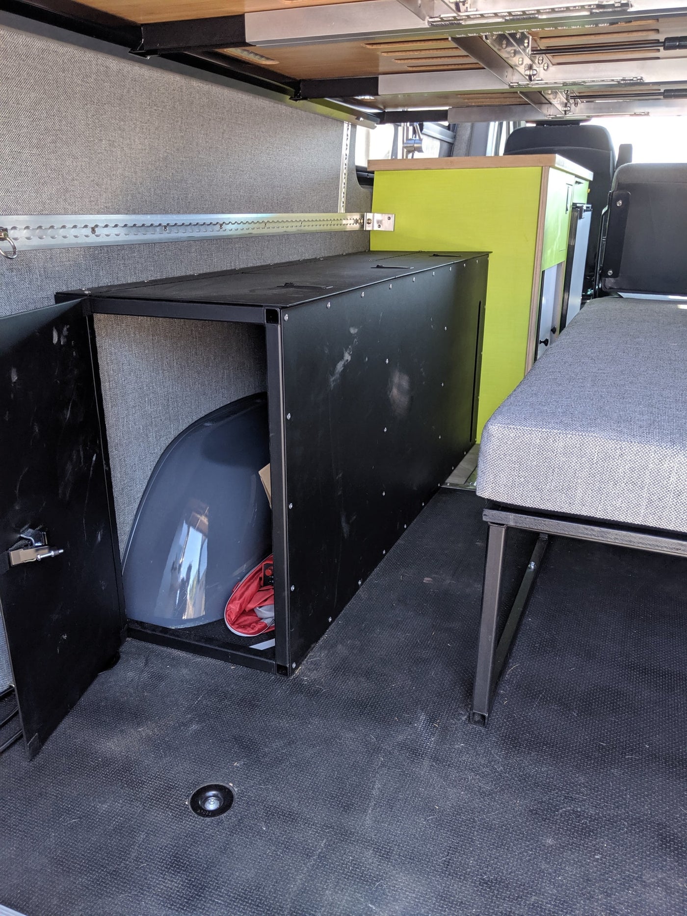 Inside an RV rental: versatile interior with black storage, L-track system, and cozy seating/bed. — photo 13