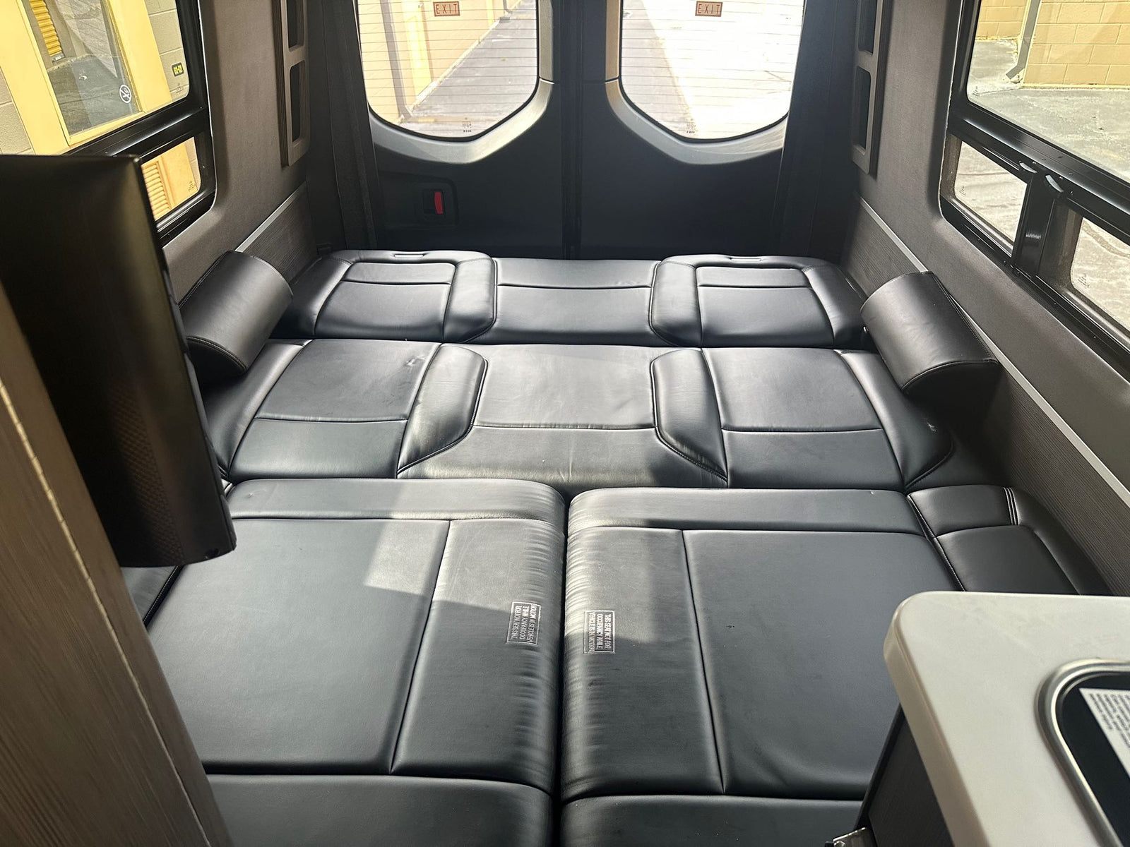 entertainment screen & ceiling vent.|This RV rental features a compact camper van kitchen with a stove