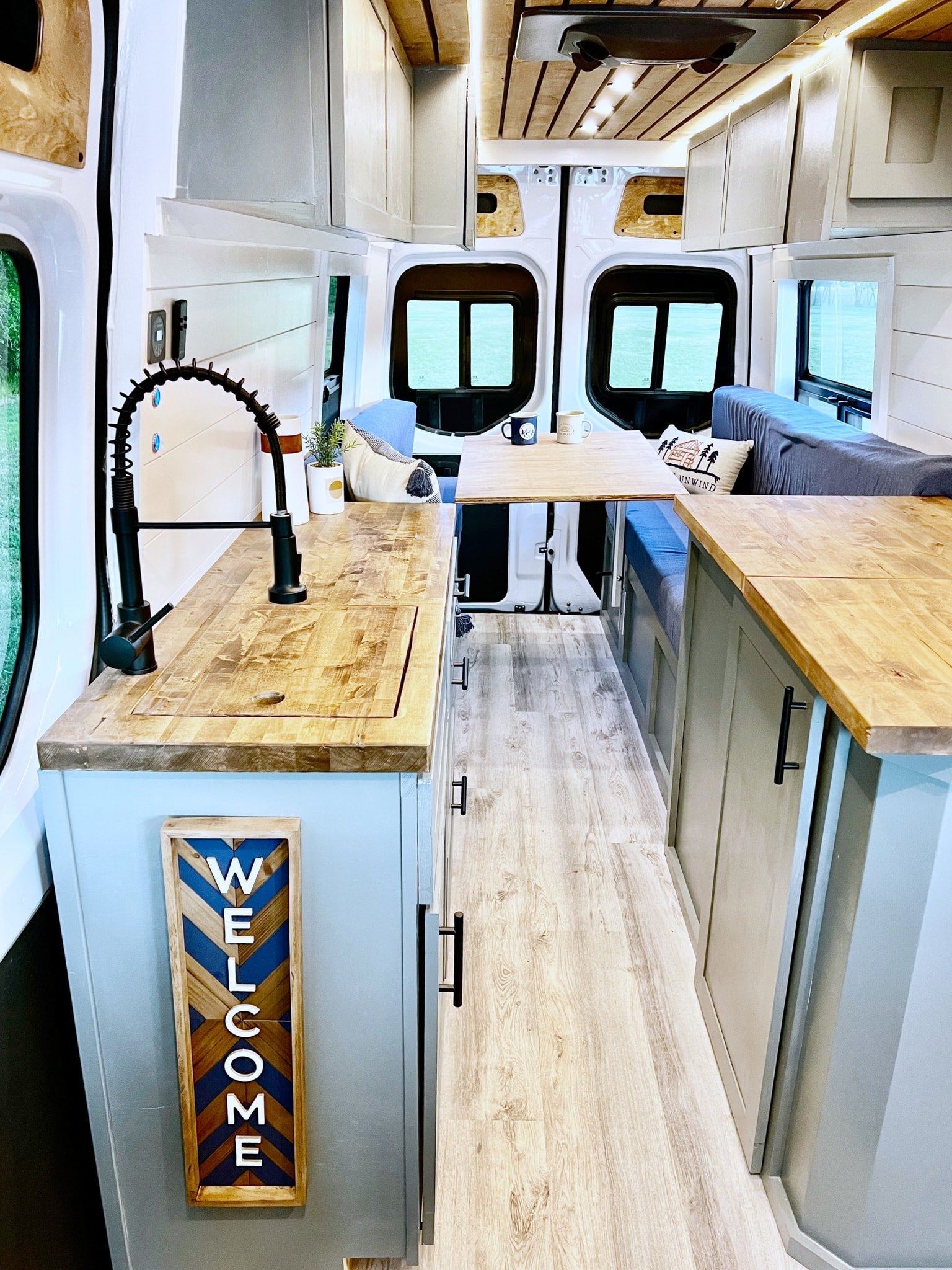 and warm wood accents. Ready for adventure!|Inside a stylish rv rental: a light-filled camper van with a compact kitchen