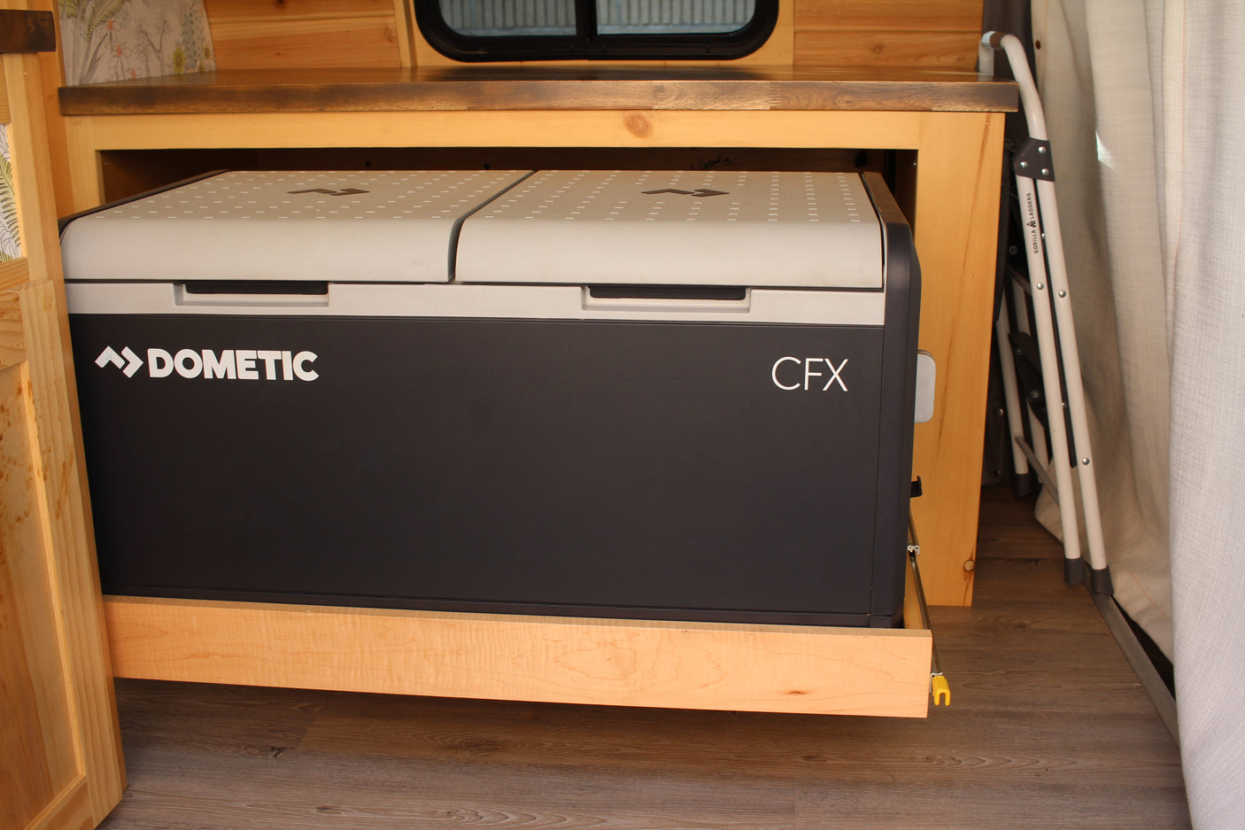 Dometic CFX fridge on a slide-out, integrated into a wood-paneled RV rental for convenient travel cooling.