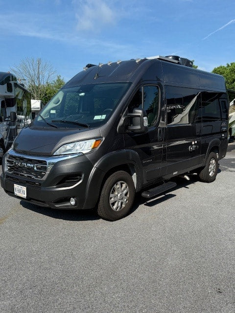 Sleek dark gray Class B RV rental parked outdoors on asphalt. Perfect for your next camper van adventure.