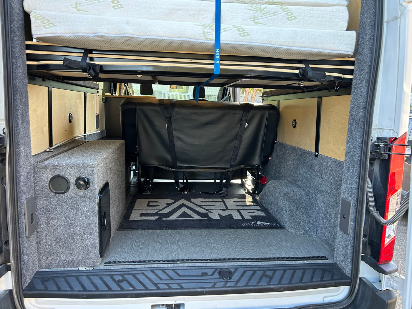 This RV rental's rear interior features clever bed storage, versatile seating, and functional custom cabinetry for adventure. — photo 4