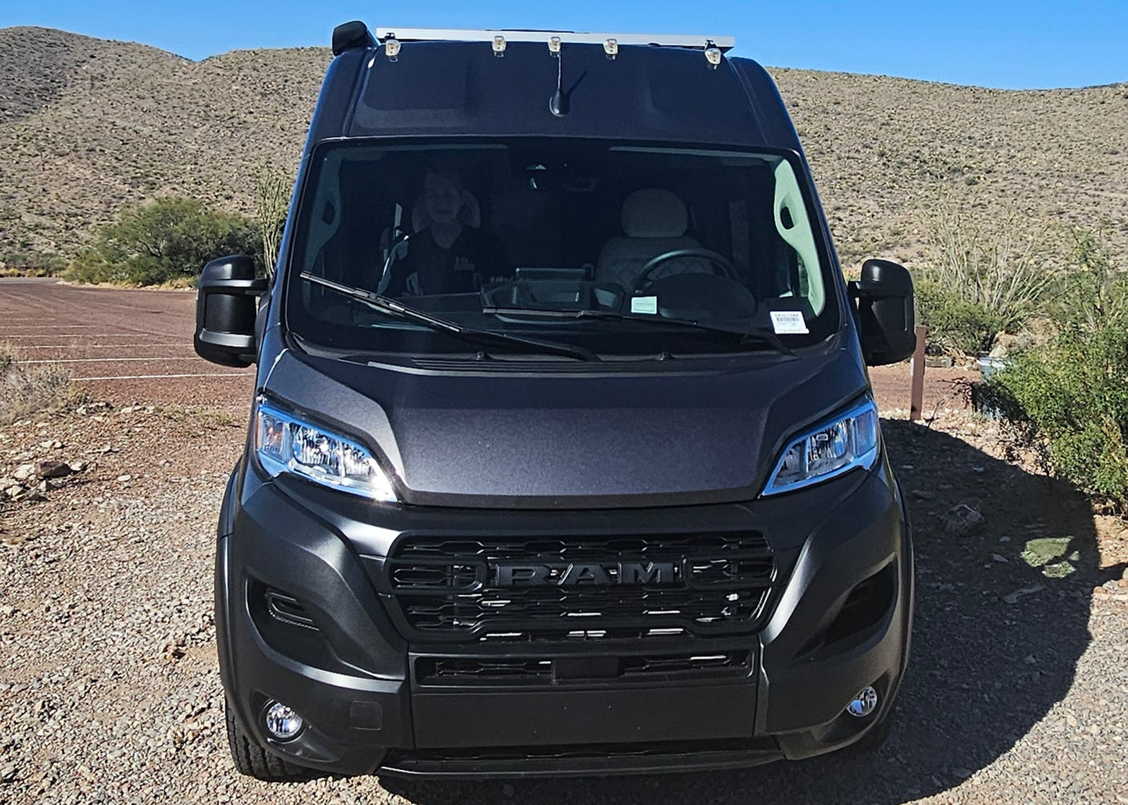 ideal for your next RV rental road trip.|Front view of a dark grey Ram ProMaster RV rental campervan