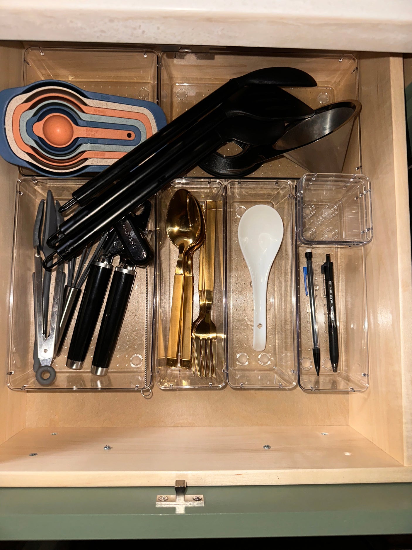 RV rental kitchen drawer: neatly organized with measuring cups, utensils, and flatware in clear bins.