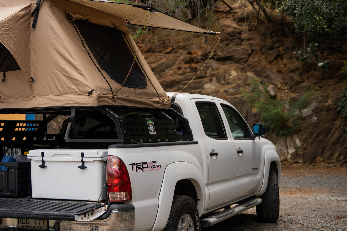 White Toyota Tacoma pickup with a rooftop tent, ready for camping. An ideal RV rental alternative for outdoor adventures.