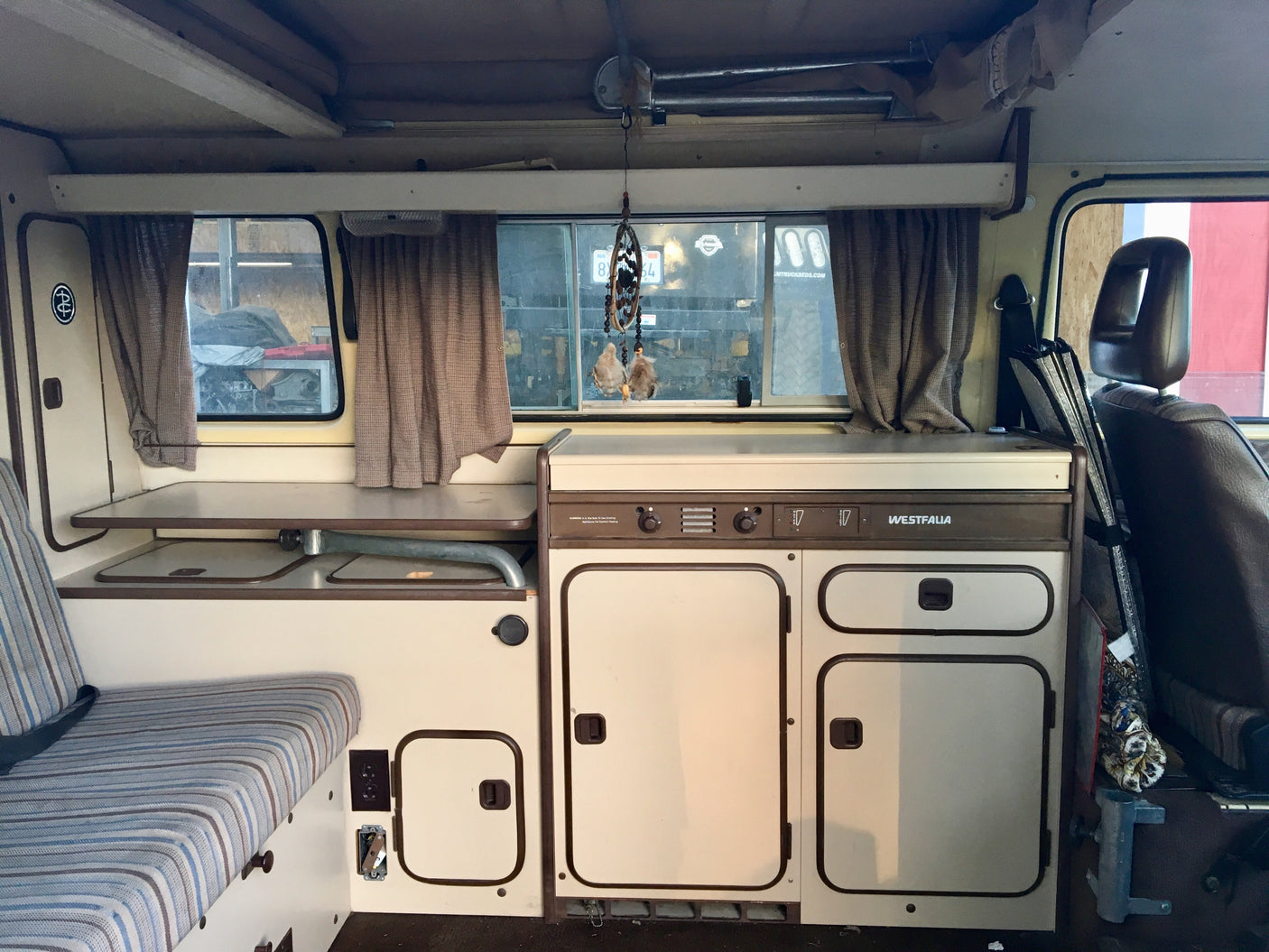 Detailed interior of a Westfalia camper van, showing compact kitchen, seating, and storage. Perfect for an rv rental adventure.