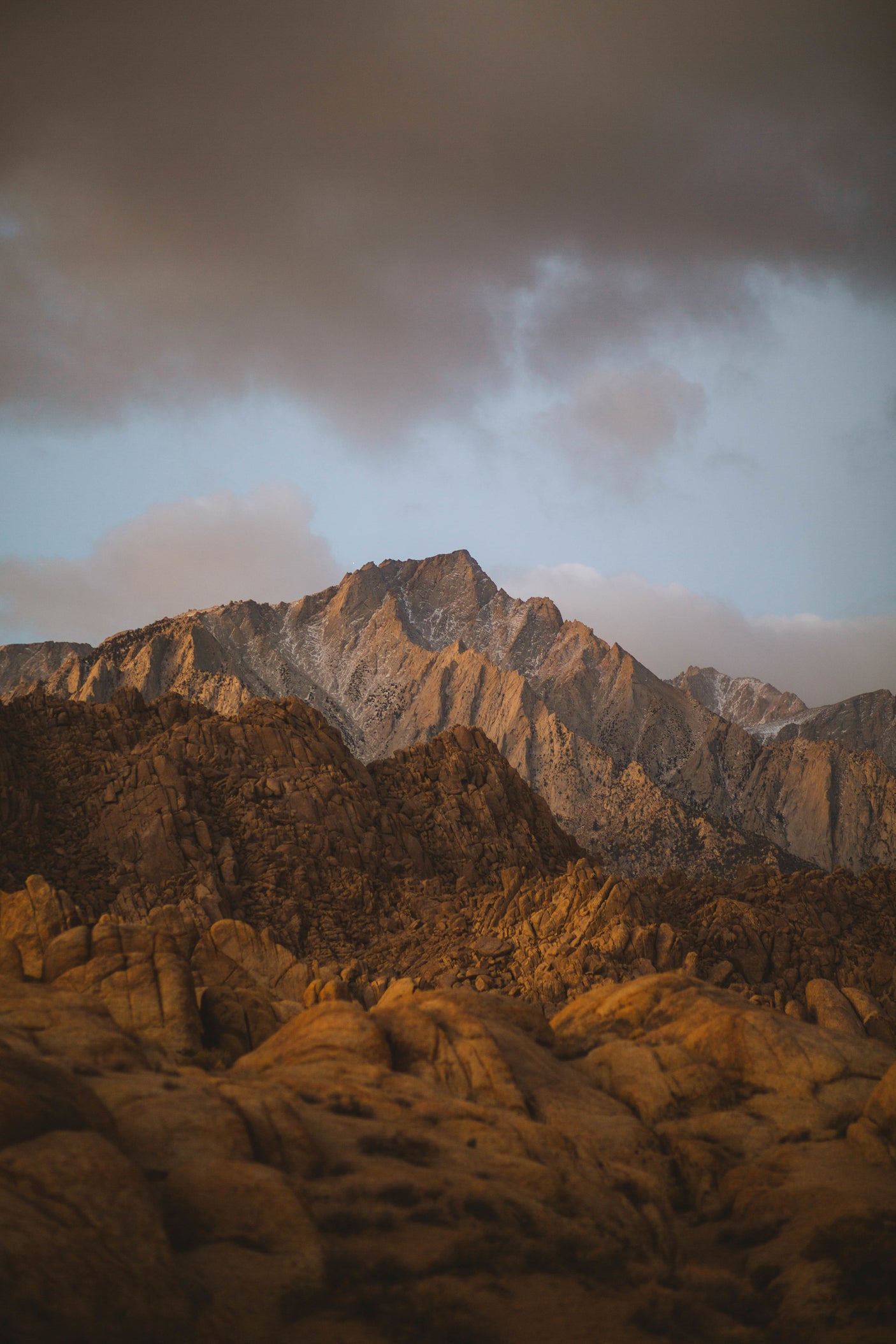 Golden light illuminates textured rock formations and majestic mountains. Discover this beauty with an RV rental adventure.