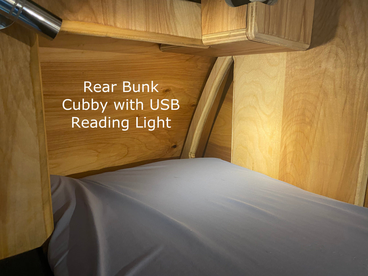 RV rental bunk area with convenient built-in cubby and USB reading light for comfortable stays.
