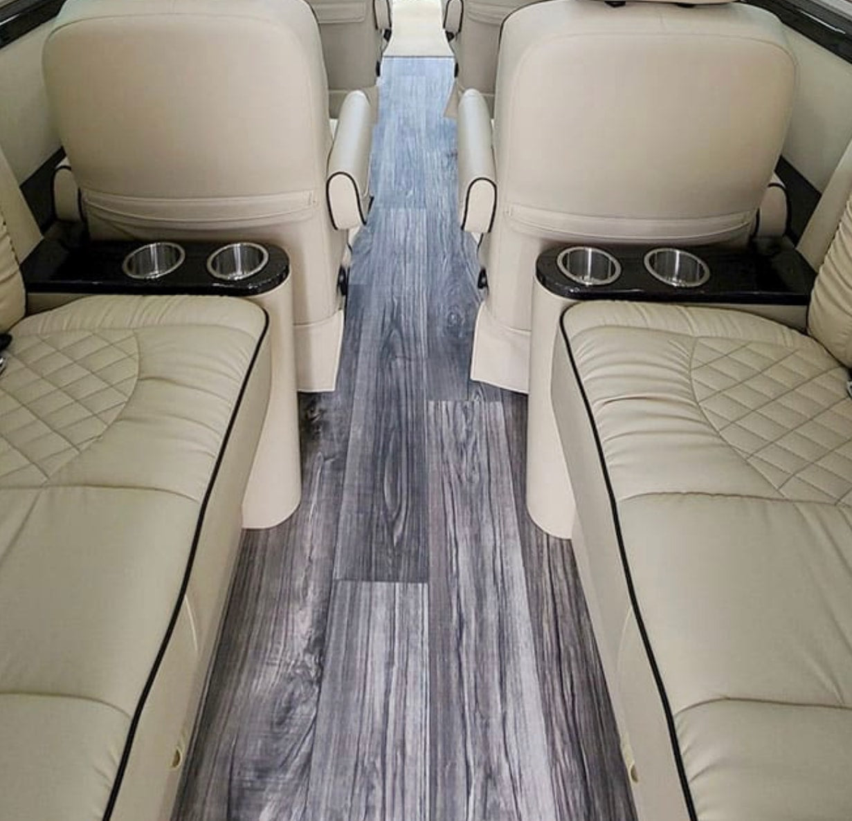 and controls for premium comfort.|Spacious luxury RV rental interior: cream quilted leather captain's chairs