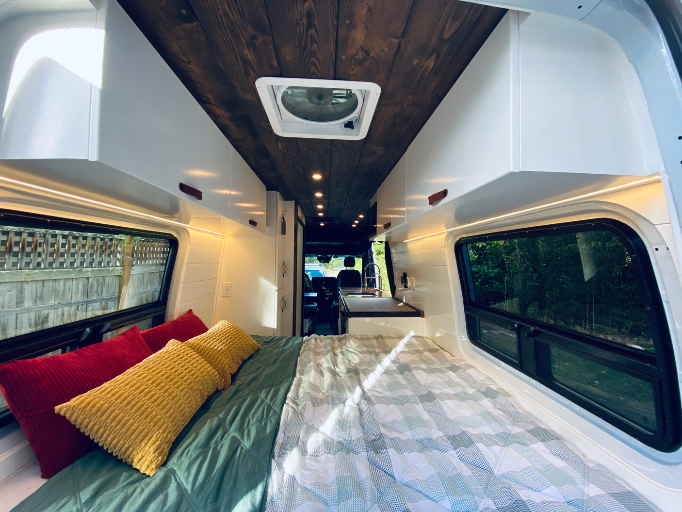 Explore comfort! This RV rental offers a cozy bed, sleek wooden ceiling, modern kitchen & ample storage for your journey.